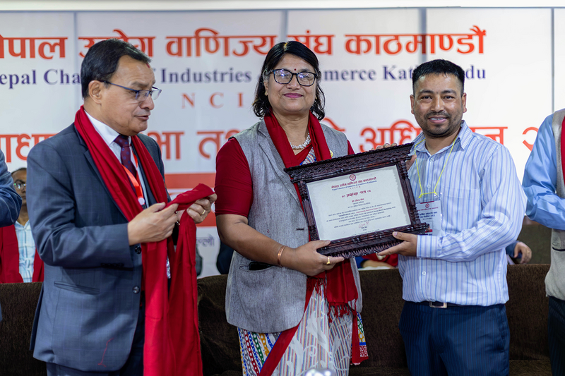 A moment of recognition at the Nepal Chamber of Industries & Commerce Kathmandu (NCICK) event, featuring the presentation of a formal Letter of Appreciation.